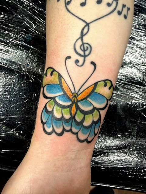 Colour butterfly and music notes forearm