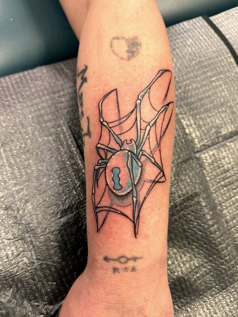 Spider and web forearm tattoo with blue shading