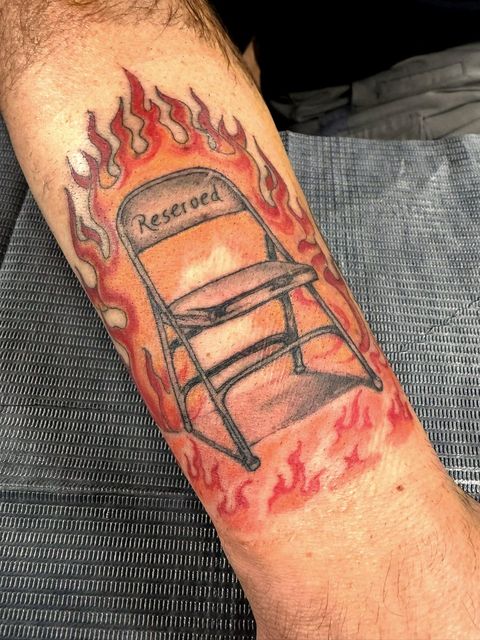 Colour traditional folding chair lettered Reserved, in flames