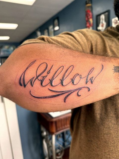 Script lettering arm tattoo